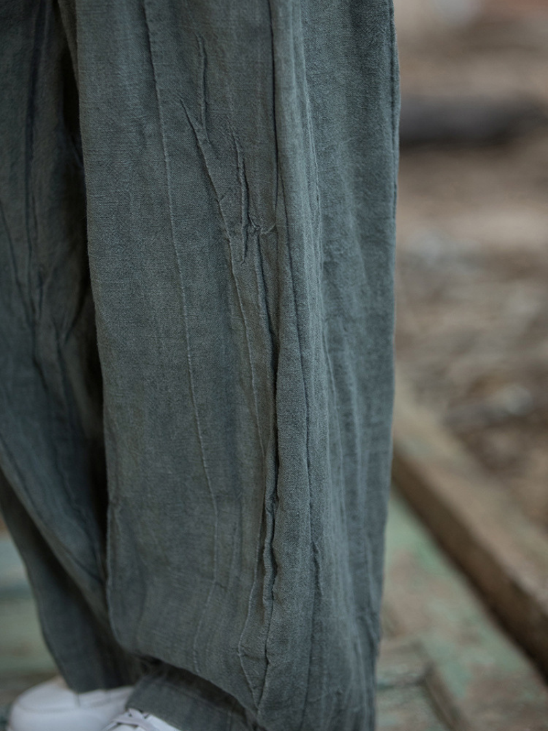 Close-up of a worn green fabric with visible stitching and texture.