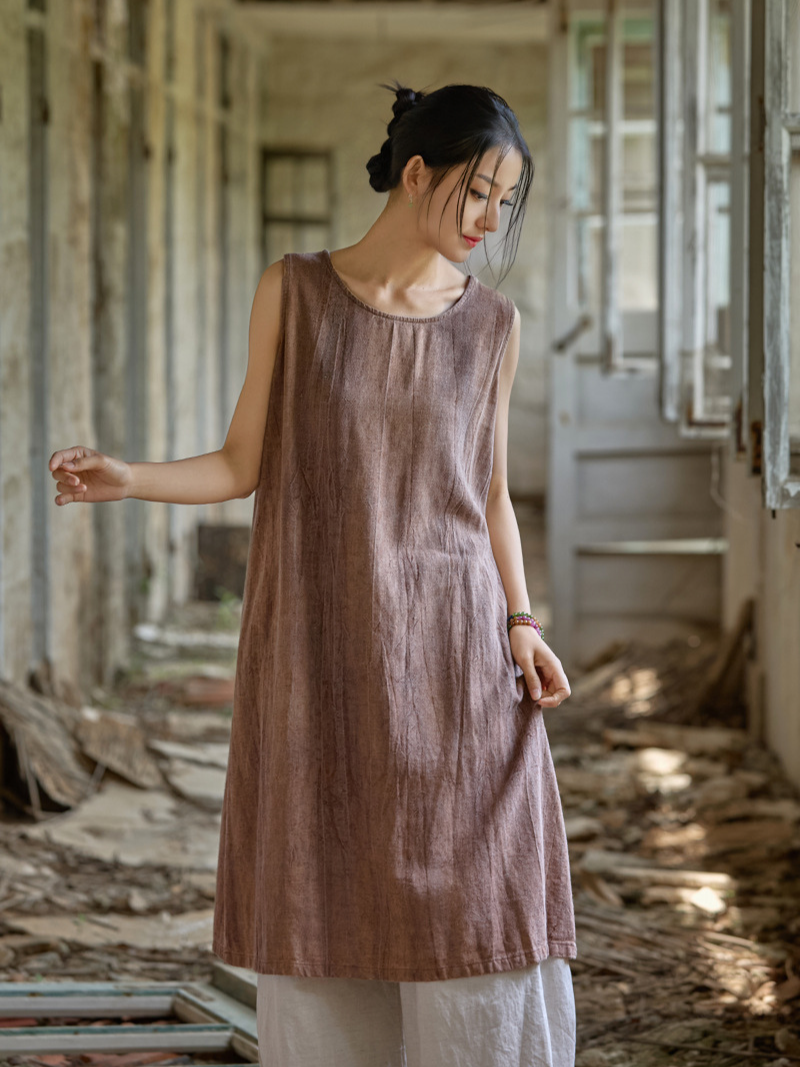Woman wearing a brown sleeveless dress in an abandoned building