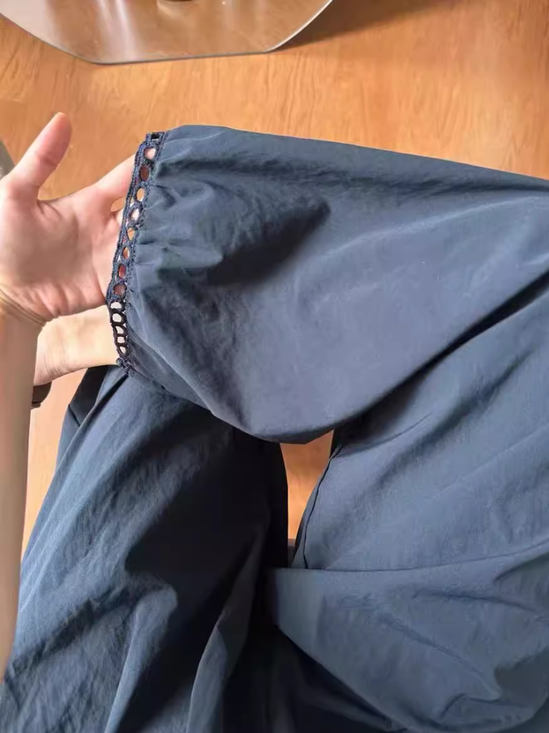 Close-up of a blue garment with a zipper on a wooden surface