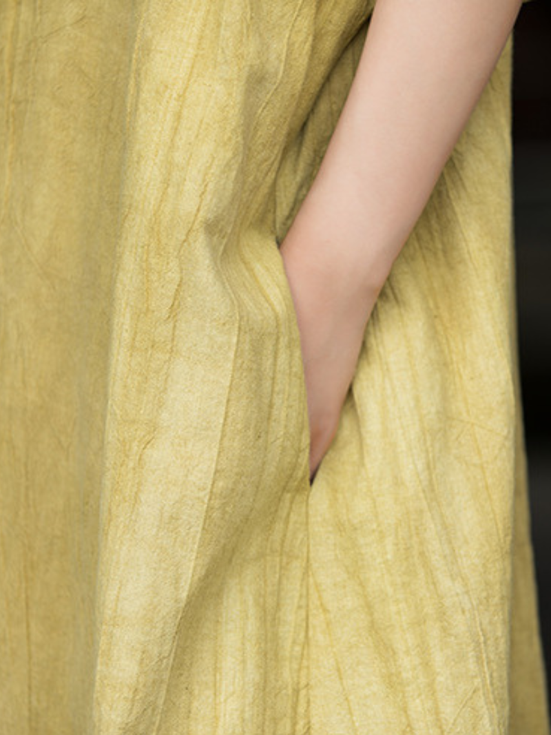 Close-up of a light green fabric with a hand partially visible