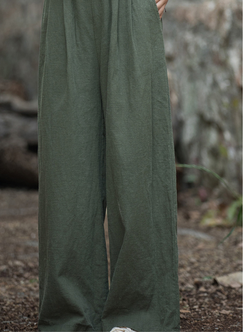 Green pants being held up against a natural background