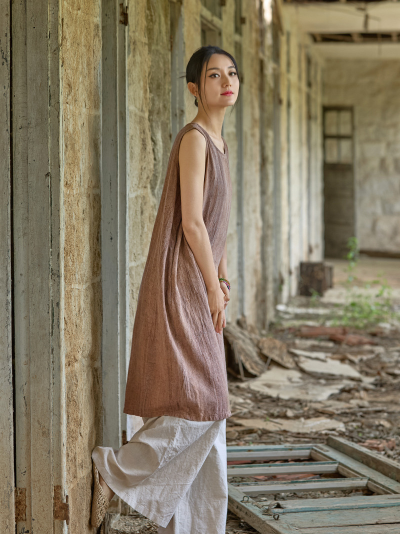 Woman in a brown dress standing in an abandoned building