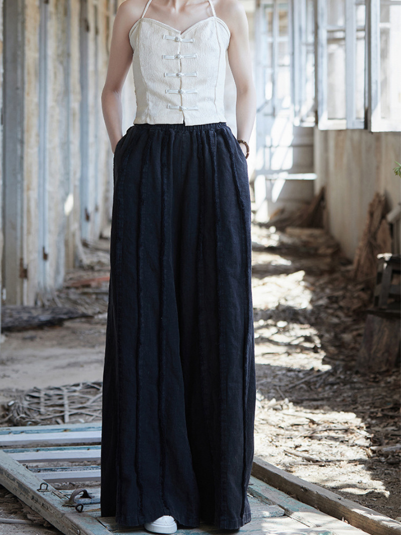 Women's  wearing a white top and dark blue skirt in an industrial setting