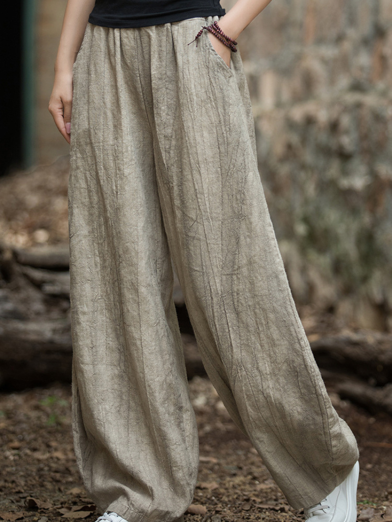 Women's  wearing beige wide-leg pants in a natural setting